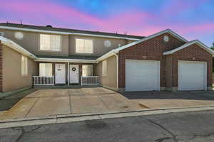Traditional-style home with an attached garage, concrete driveway, and brick siding