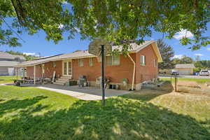 Rear view of property with a patio, brick siding, entry steps, french doors, and a gate