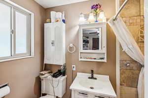 Bathroom featuring a tile shower and vanity