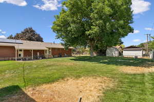 Fenced backyard featuring a patio and a shed