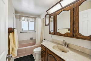 Full bath with vanity, shower / tub combo with curtain, and tile patterned flooring