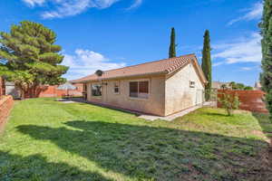 Back of property featuring a fenced backyard, a tile roof, stucco siding, and a patio area