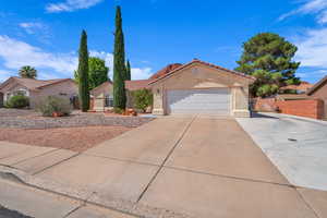 Mediterranean / spanish-style house featuring driveway, an attached garage, stucco siding, and a tiled roof