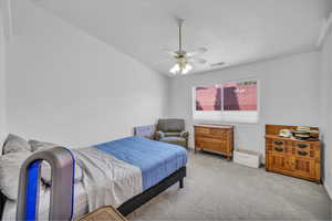 Carpeted bedroom featuring ceiling fan