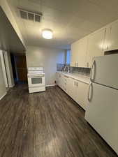Full bathroom with shower / tub combo with curtain and dark wood-style flooring