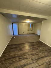 Kitchen featuring white cabinets, white appliances, light countertops, dark wood-style flooring, and tasteful backsplash