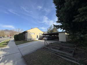 View of home's exterior with driveway, a mountain view, and a carport