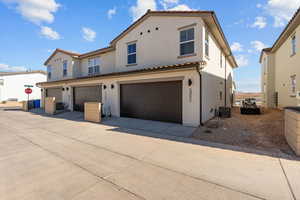 Mediterranean / spanish home featuring stucco siding, a tiled roof, a garage, and concrete driveway