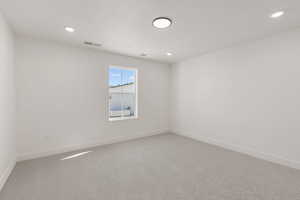 Empty room featuring light carpet and recessed lighting