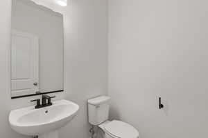 Half bathroom with toilet and a sink