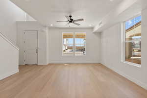 Unfurnished room with plenty of natural light, light wood finished floors, a ceiling fan, and recessed lighting