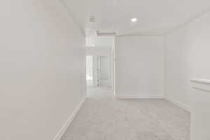 Unfurnished room with light carpet, attic access, and recessed lighting