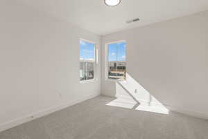 Spare room featuring carpet flooring and baseboards