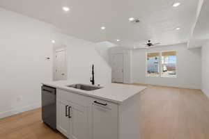 Kitchen featuring light wood-style floors, white cabinetry, open floor plan, recessed lighting, and stainless steel dishwasher