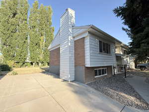 View of side of property featuring brick siding and a chimney