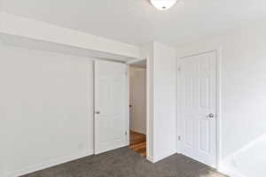 Bedroom featuring carpet and a textured ceiling
