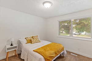 Bedroom featuring carpet and a textured ceiling