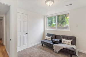 Bedroom with a textured ceiling and light colored carpet