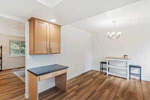 Kitchen with light wood finished floors, a chandelier, dark countertops, recessed lighting, and hanging light fixtures