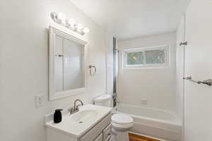 Full bath featuring vanity, bathing tub / shower combination, and a textured ceiling