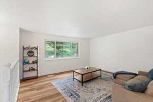 Living room with a textured ceiling and light wood finished floors