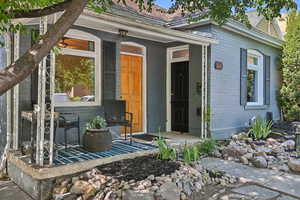 Doorway to property featuring brick siding and roof with shingles