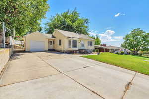 Ranch-style home with a garage, concrete driveway, a front lawn, and roof with shingles