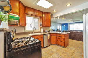 Kitchen with open floor plan, a peninsula, dishwasher, light tile patterned floors, and recessed lighting