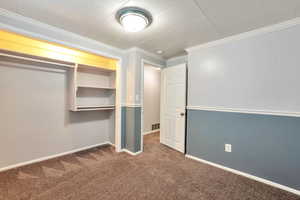 Unfurnished bedroom with carpet, crown molding, and a closet