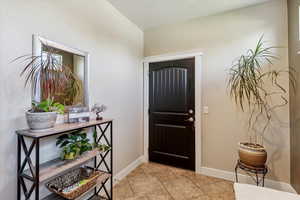 Entrance foyer featuring baseboards and light tile patterned floors