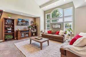 Living area with a towering ceiling and recessed lighting