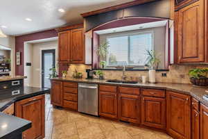 Kitchen with plenty of natural light, dishwasher, decorative backsplash, recessed lighting, and brown cabinetry