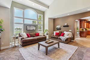 Living room featuring high vaulted ceiling, recessed lighting, and arched walkways