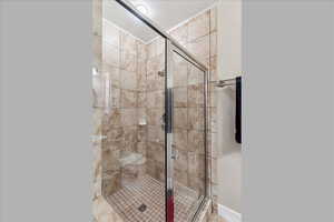 Bathroom with a stall shower and baseboards