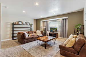Living area featuring carpet flooring, recessed lighting, and a textured ceiling