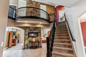 Stairway with a towering ceiling, arched walkways, and recessed lighting