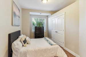 Carpeted bedroom featuring baseboards and a closet