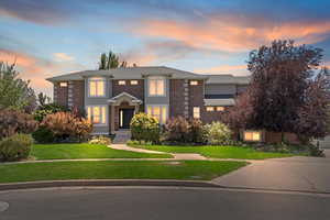 View of front of property with brick siding and a yard