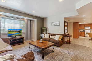 Living area with recessed lighting, light carpet, and a textured ceiling