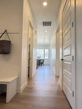 Hallway featuring light wood-style flooring, recessed lighting, a chandelier, and a textured ceiling