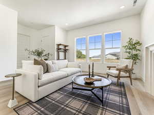 Living room with light wood-style flooring and recessed lighting