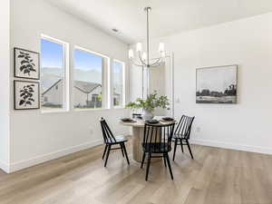 Dining space with a chandelier, light wood finished floors, and a mountain view