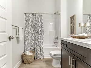 Bathroom with shower / bath combo, vanity, and light wood-style floors