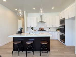 Kitchen with tasteful backsplash, a breakfast bar, white cabinets, and recessed lighting