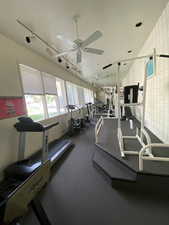 Gym with a ceiling fan and rail lighting