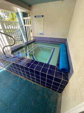 View of swimming pool featuring a hot tub and a swimming pool