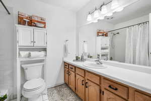 Bathroom featuring vanity, tile patterned floors, and shower / bath combo with shower curtain