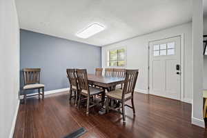 Dining and entry with wood flooring and crown molding.