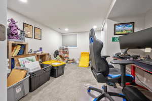Carpeted home office or bedroom with recessed lighting.
