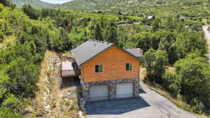 Aerial view of property and surrounding area with a forest